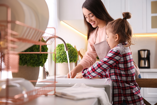A mom and daughter using the kitchen sink in a Toronto, ON, home.
